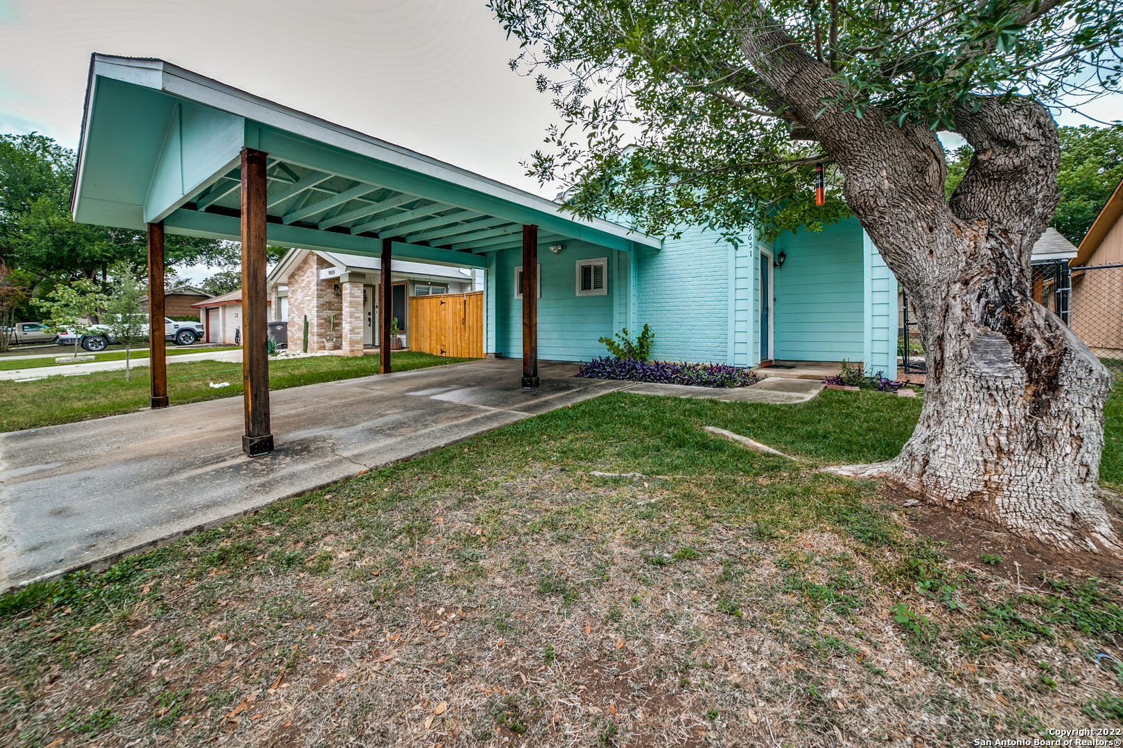 a view of a house with backyard and a tree