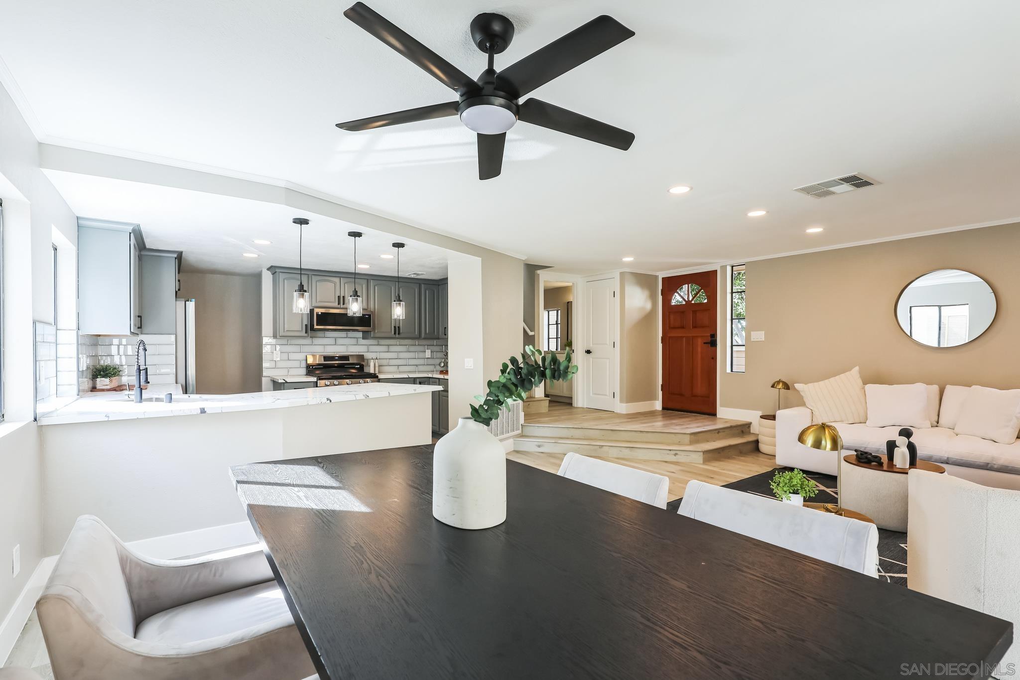 a living room with kitchen island furniture and a view of kitchen