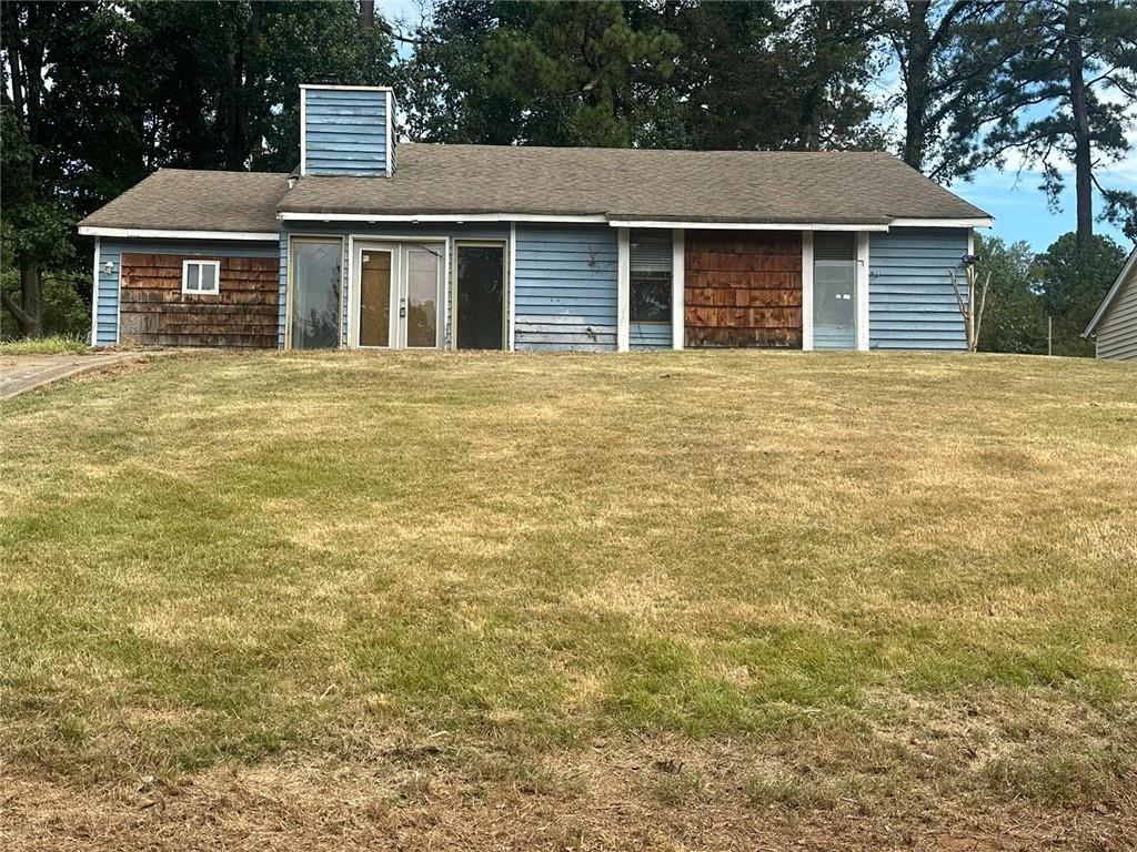 a front view of house with yard and trees around