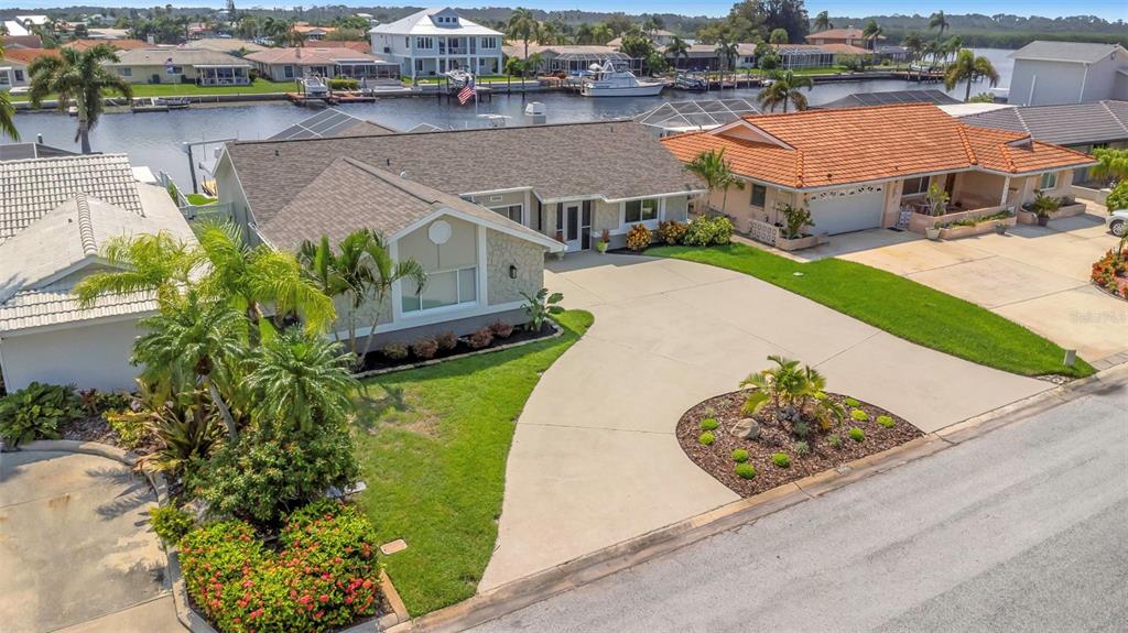 an aerial view of a house with a garden and lake view