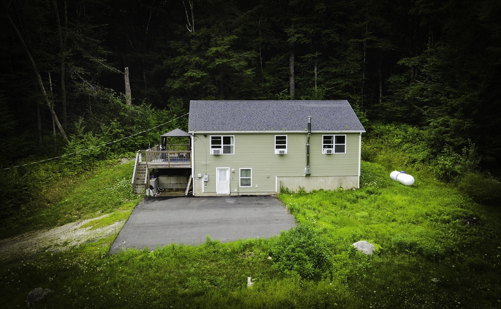 a aerial view of a house with table and chairs under an umbrella