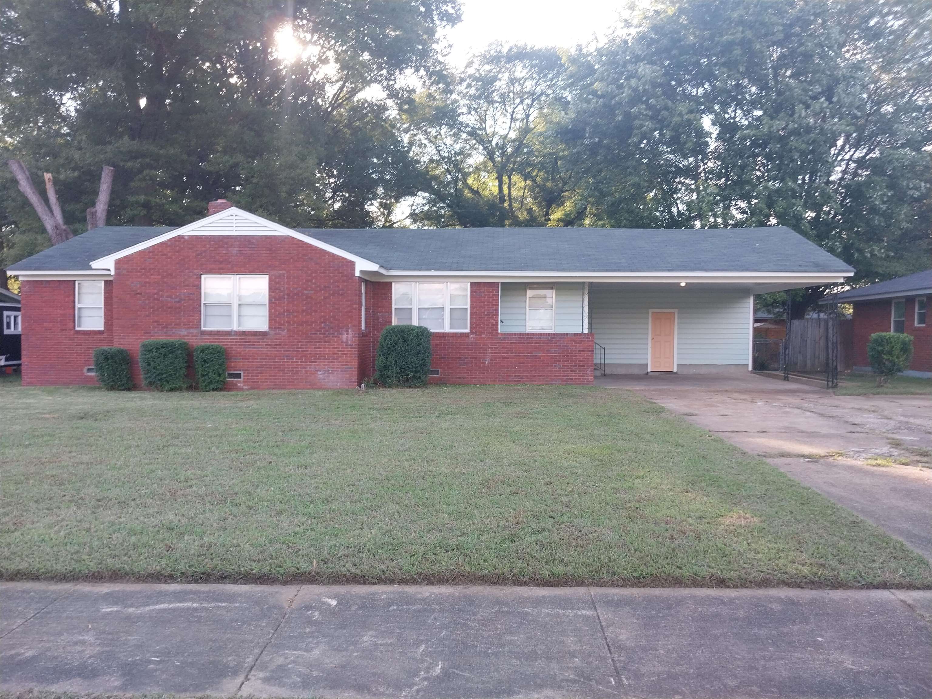 Ranch-style home with a carport and a front lawn