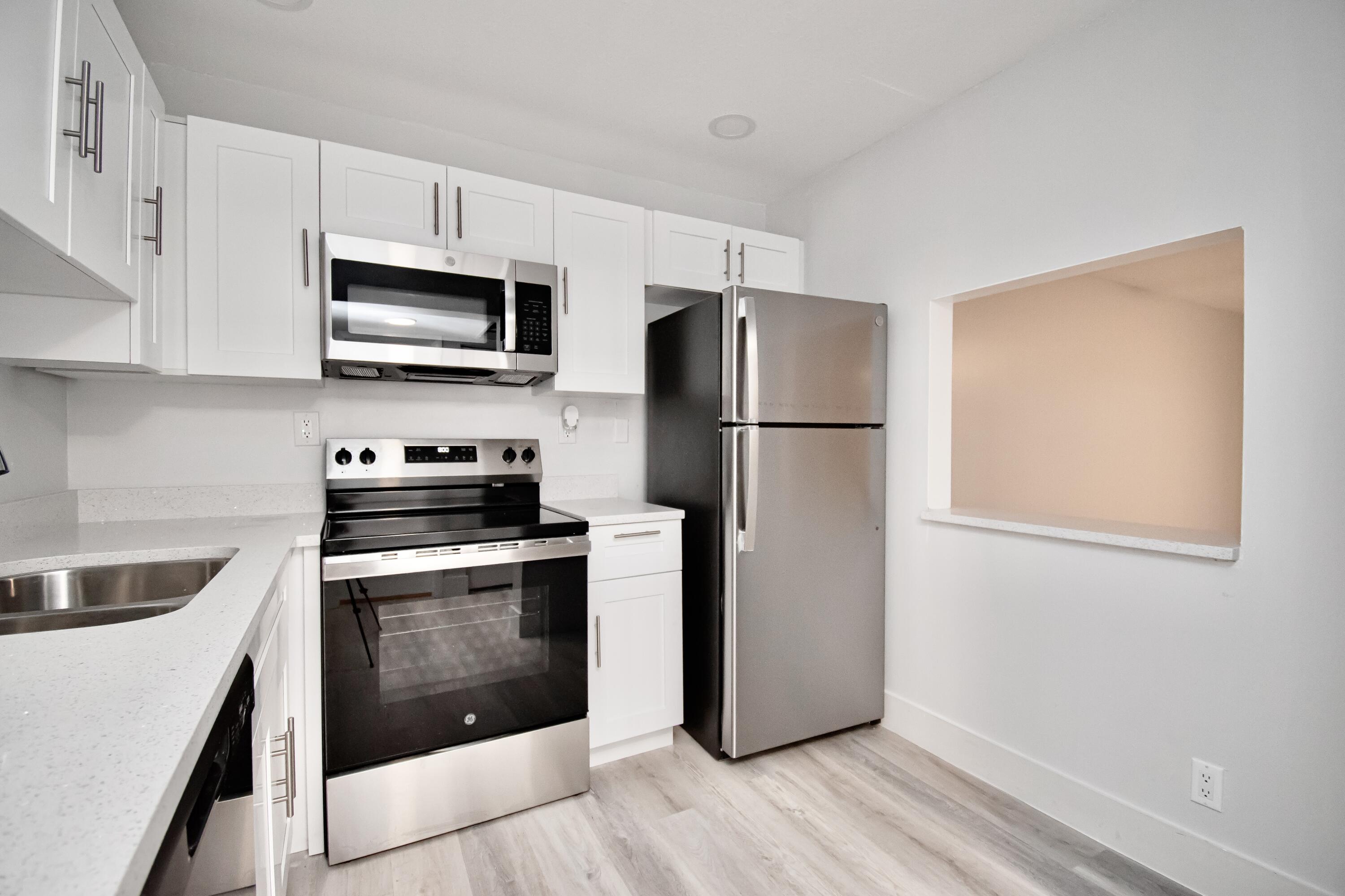 a kitchen with stainless steel appliances a refrigerator stove and microwave