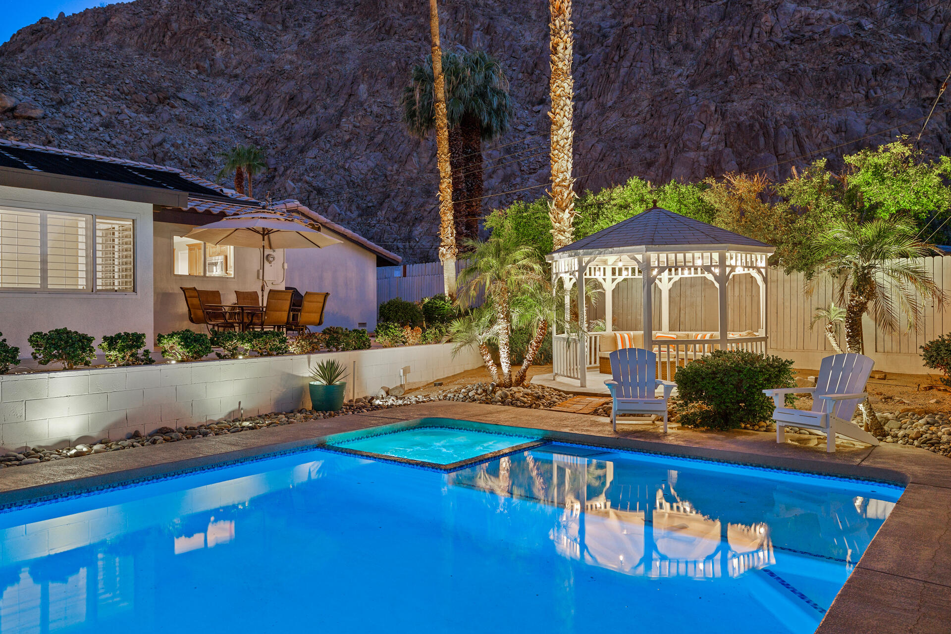 a view of a house with a swimming pool and sitting area