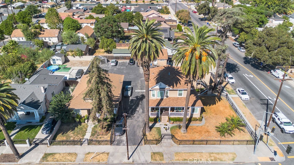 an aerial view of residential houses with outdoor space and trees