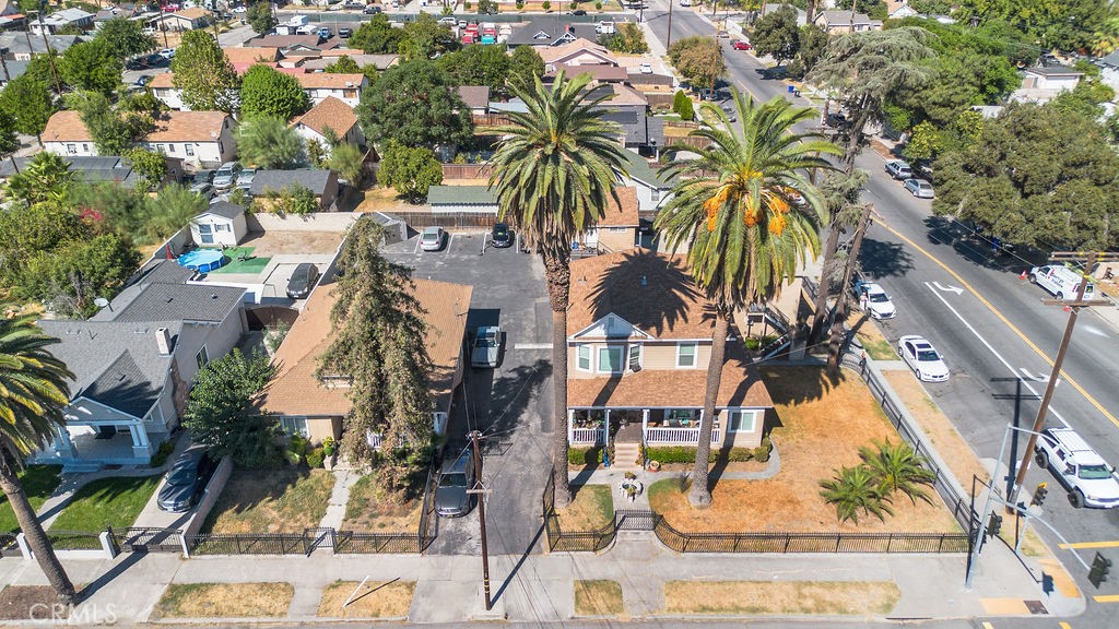 an aerial view of residential houses with outdoor space and trees