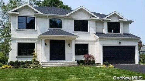 a front view of a house with a yard and garage