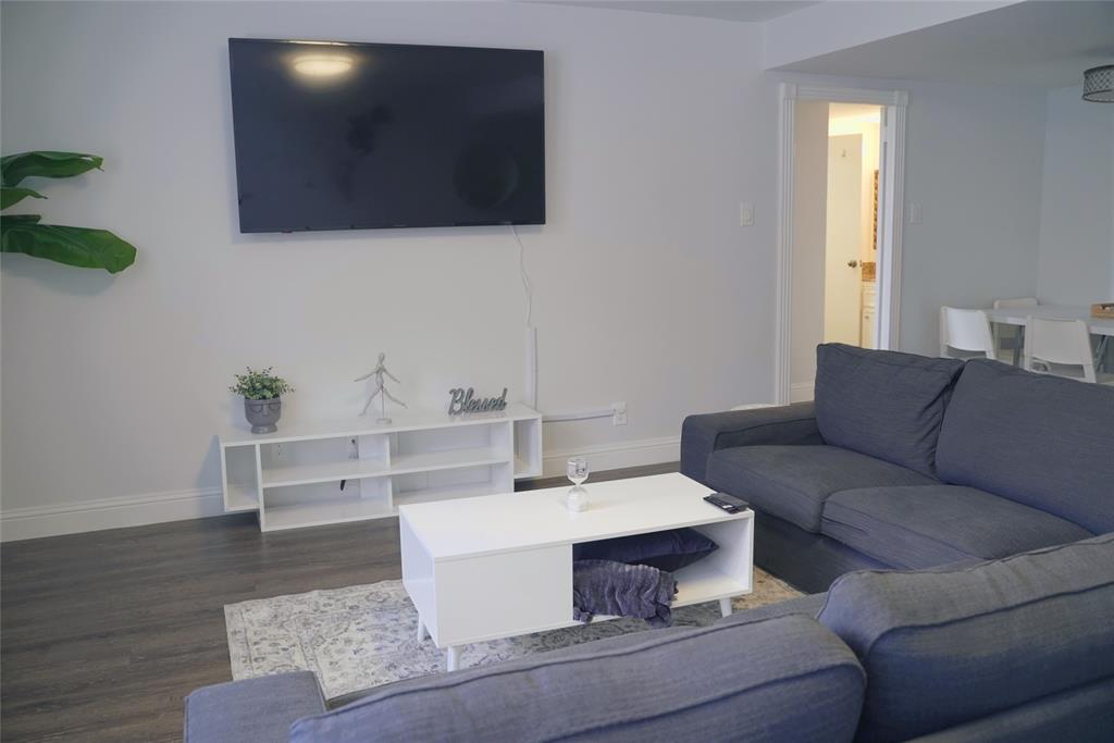 a living room with furniture a flat screen tv and a window