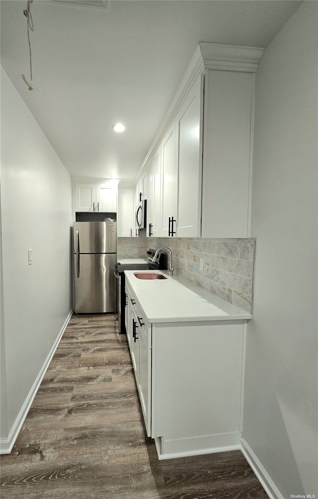 a kitchen with refrigerator cabinets and wooden floor