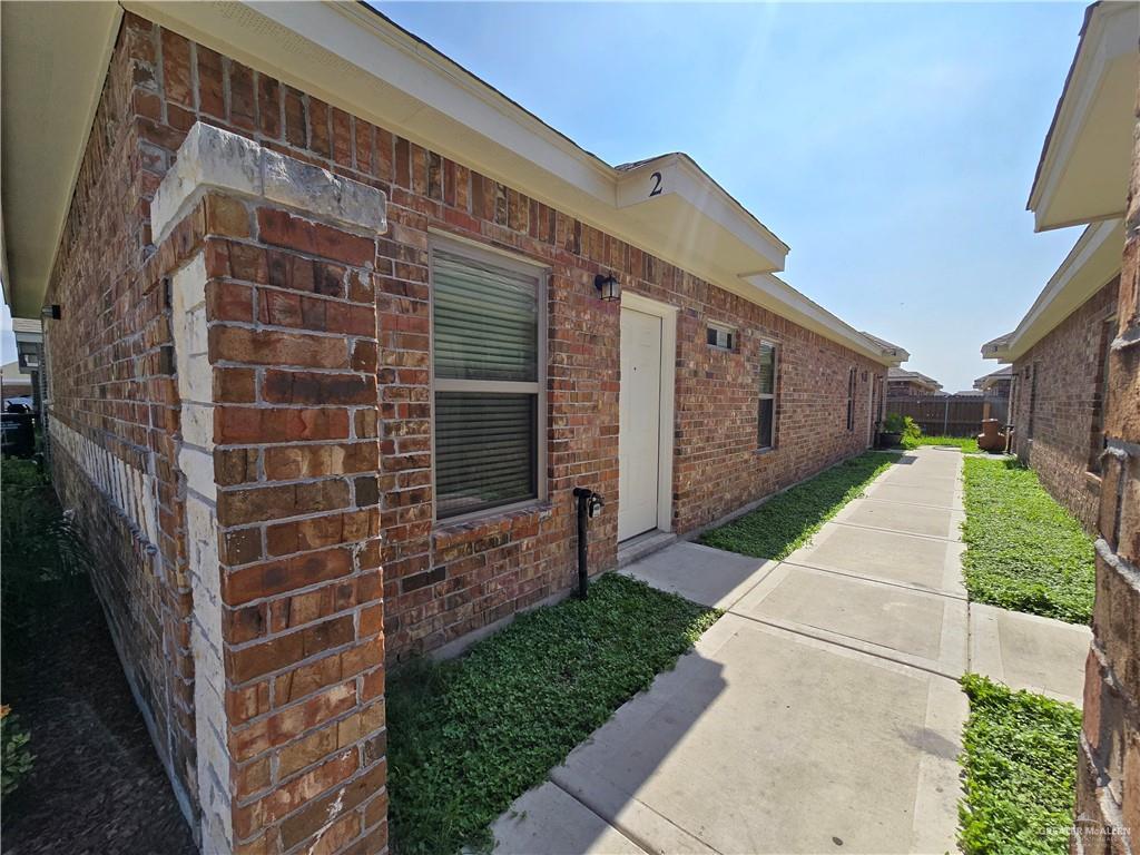 a view of a brick house with a yard and pathway