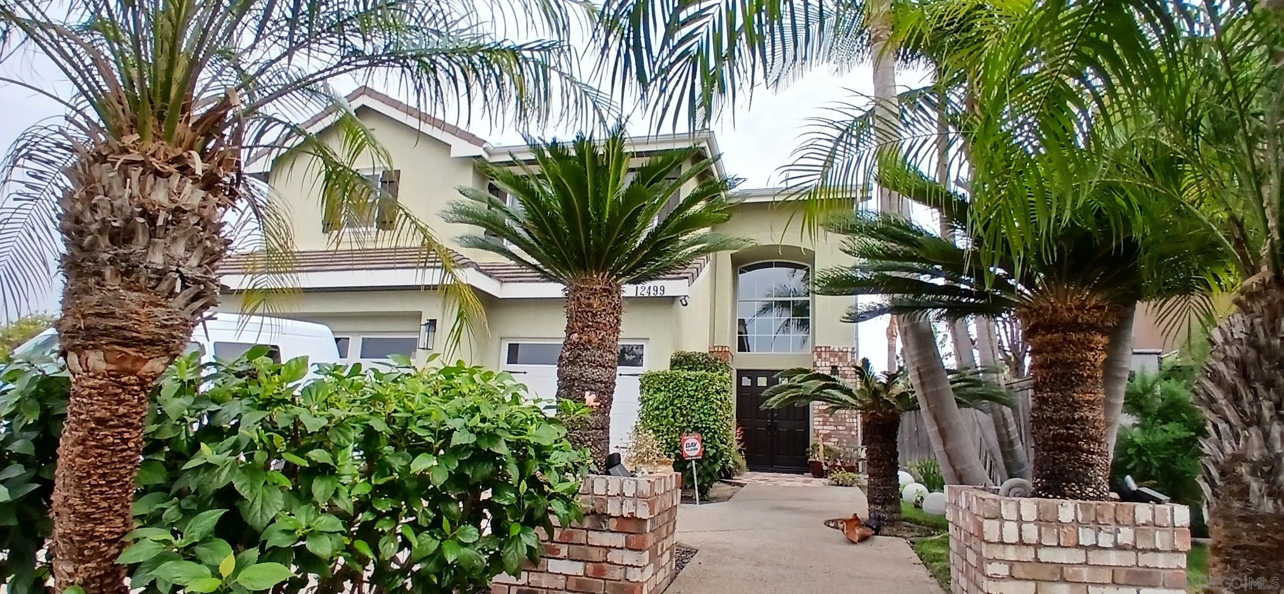 a front view of a house with a tree