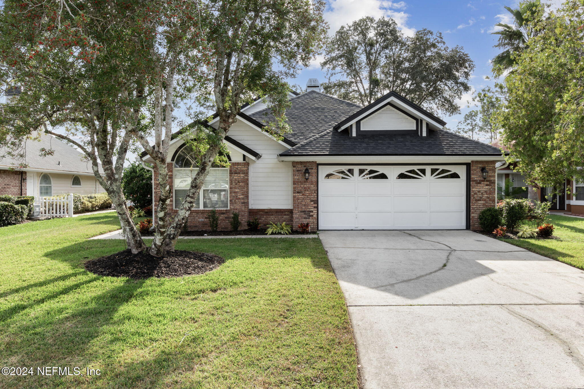 a front view of a house with a yard garage and fountain