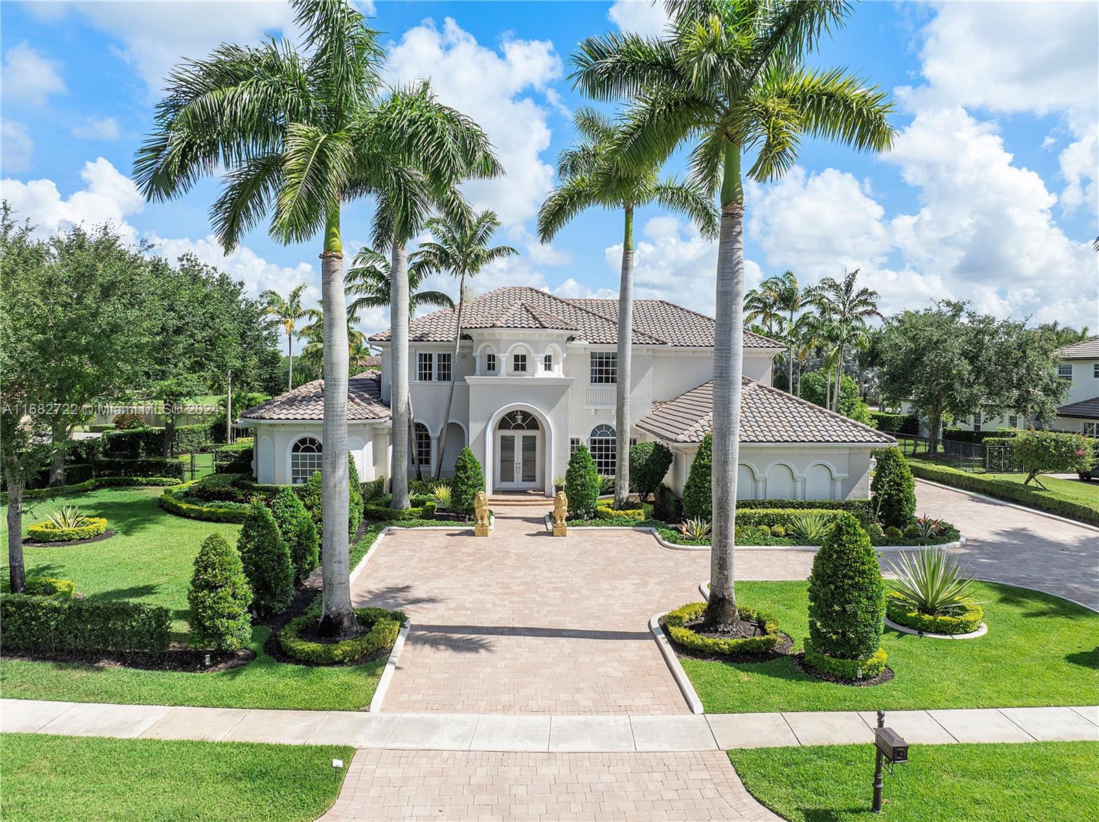 a front view of a house with garden and trees