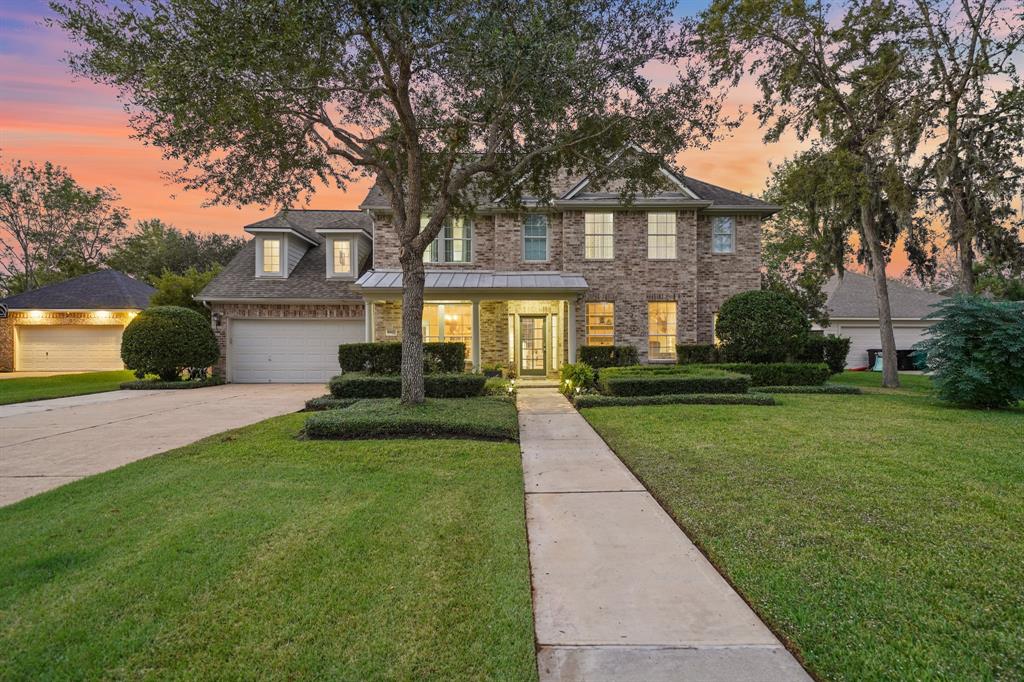 a front view of a house with a yard and trees