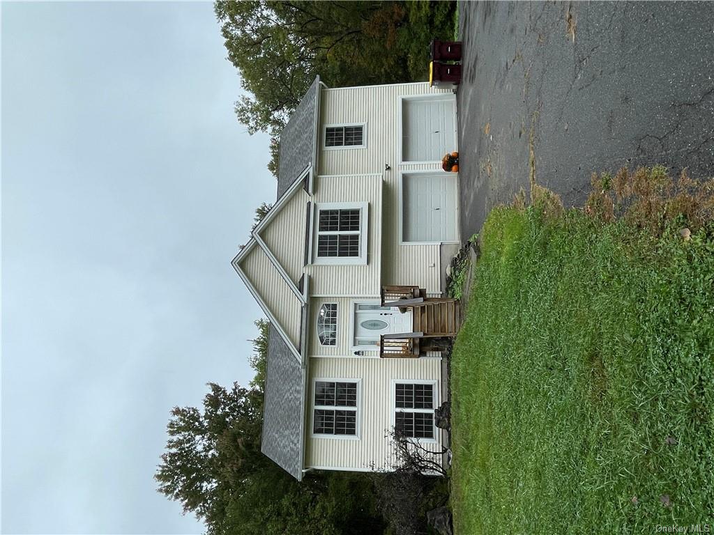 Bi-level home featuring a garage and a front yard