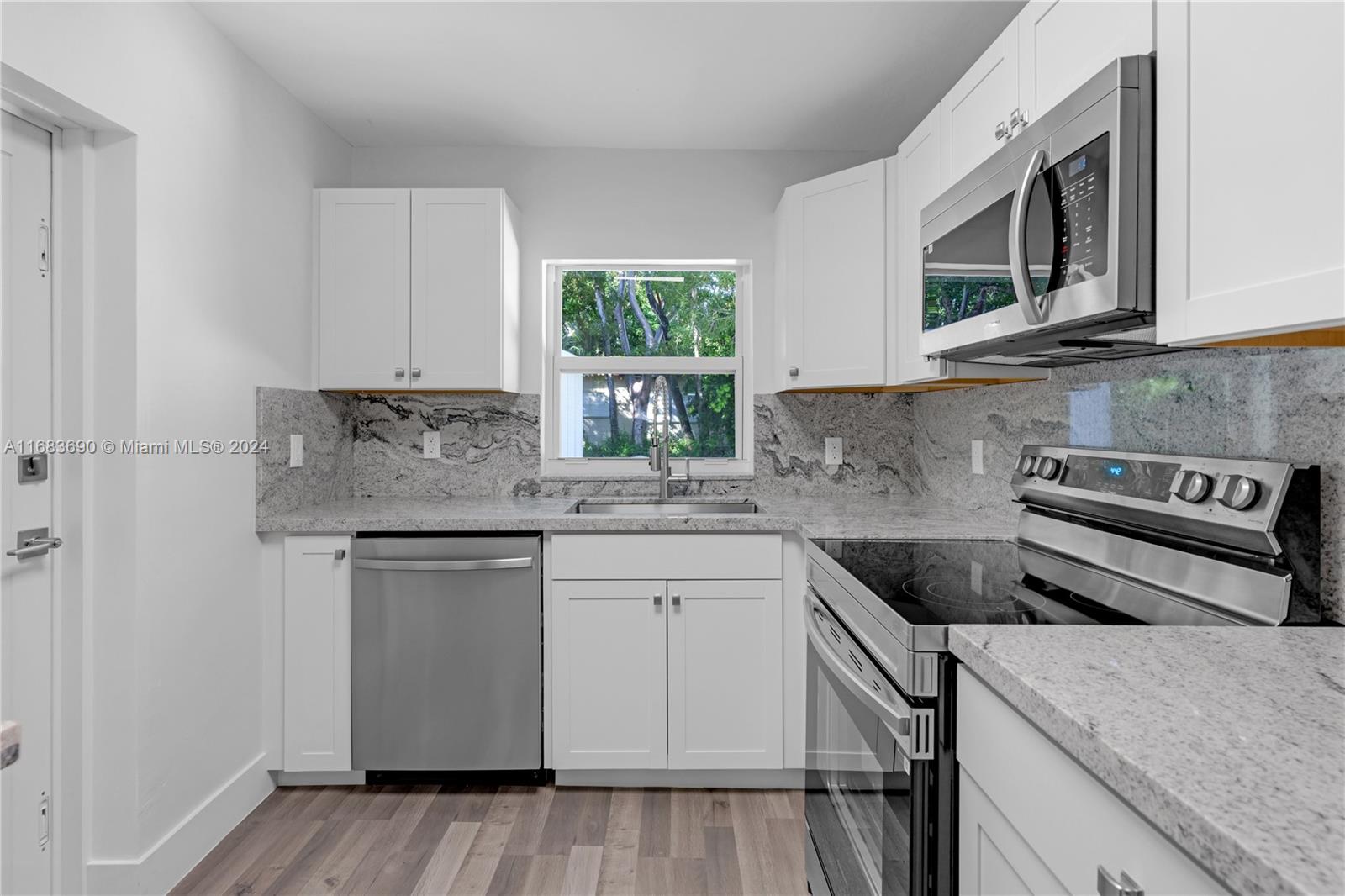 a kitchen with stainless steel appliances granite countertop a sink a stove a microwave and cabinets