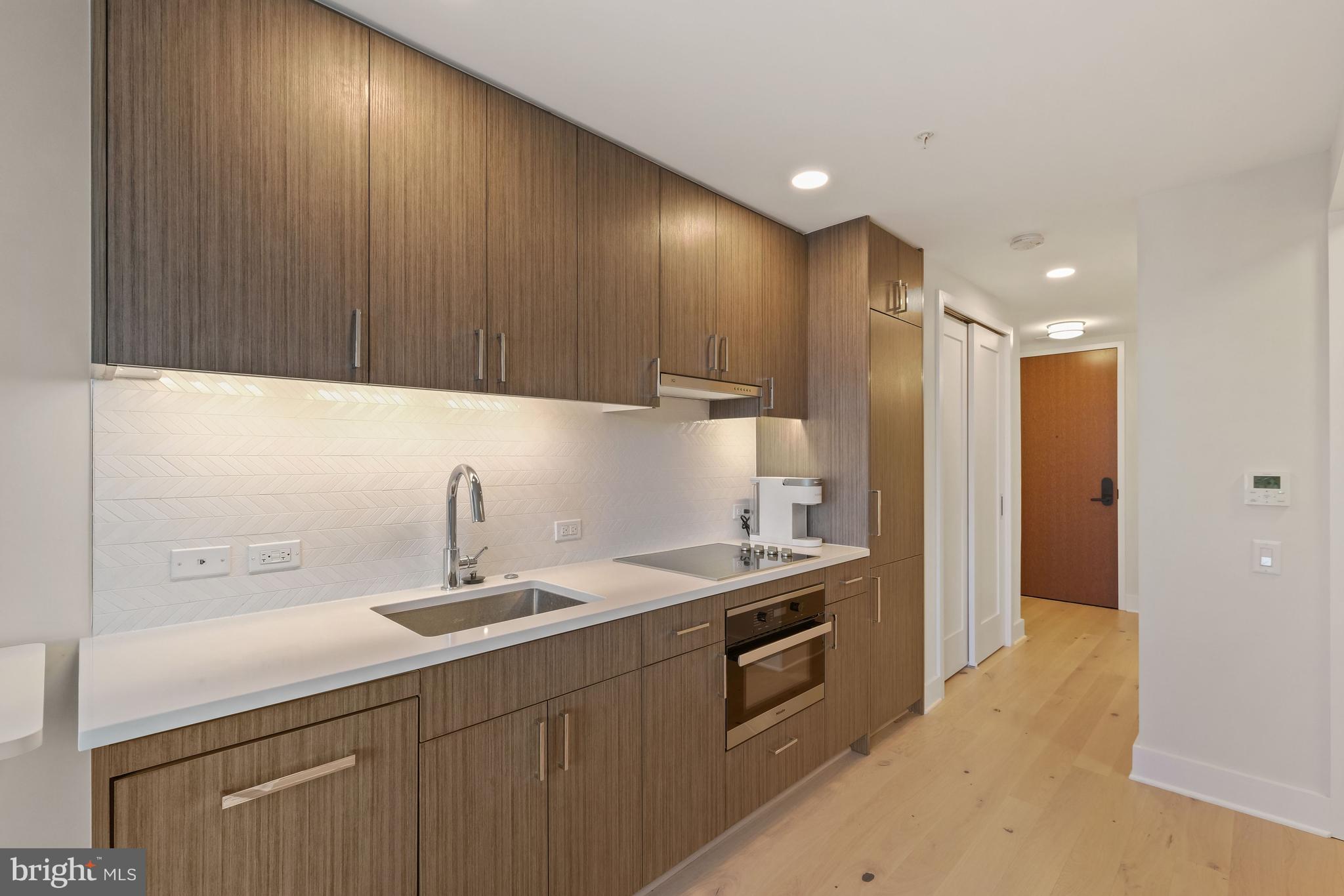 a kitchen with a sink a refrigerator and cabinets