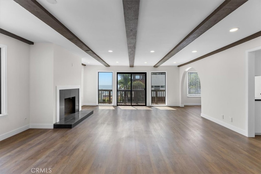 an empty room with wooden floor and fireplace