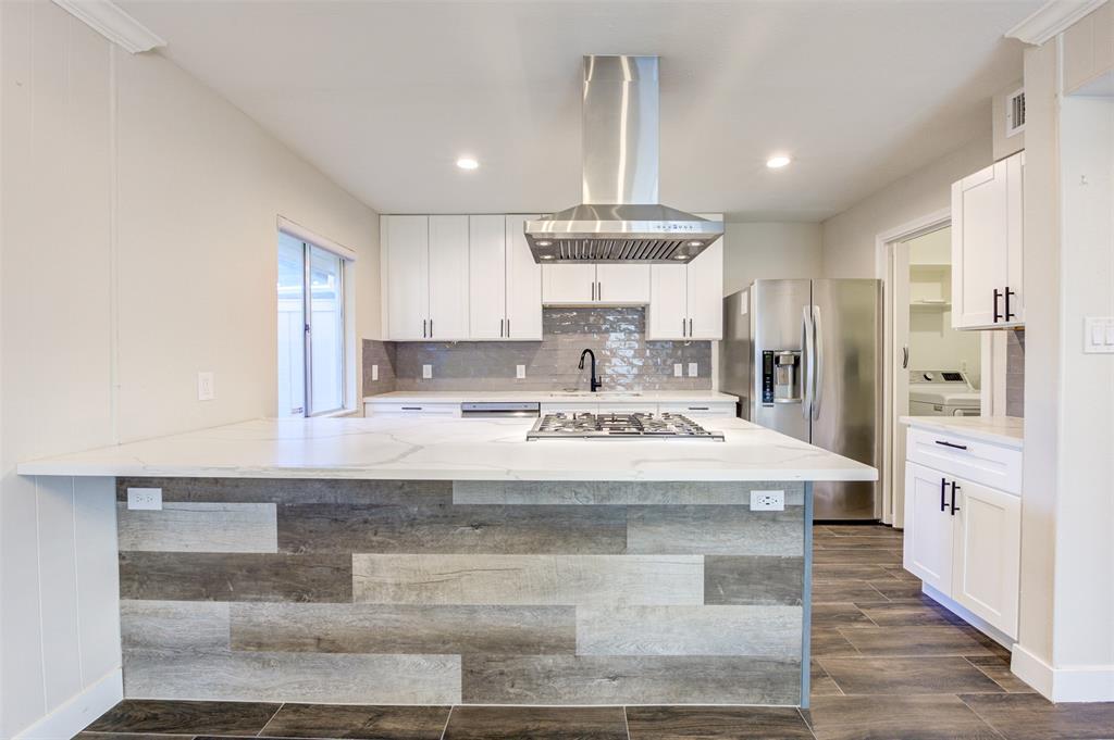 a view of kitchen with stainless steel appliances kitchen island sink stove and refrigerator