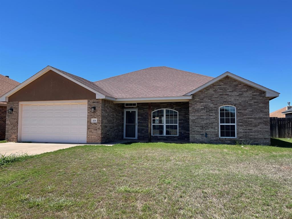 a view of a brick house with a yard