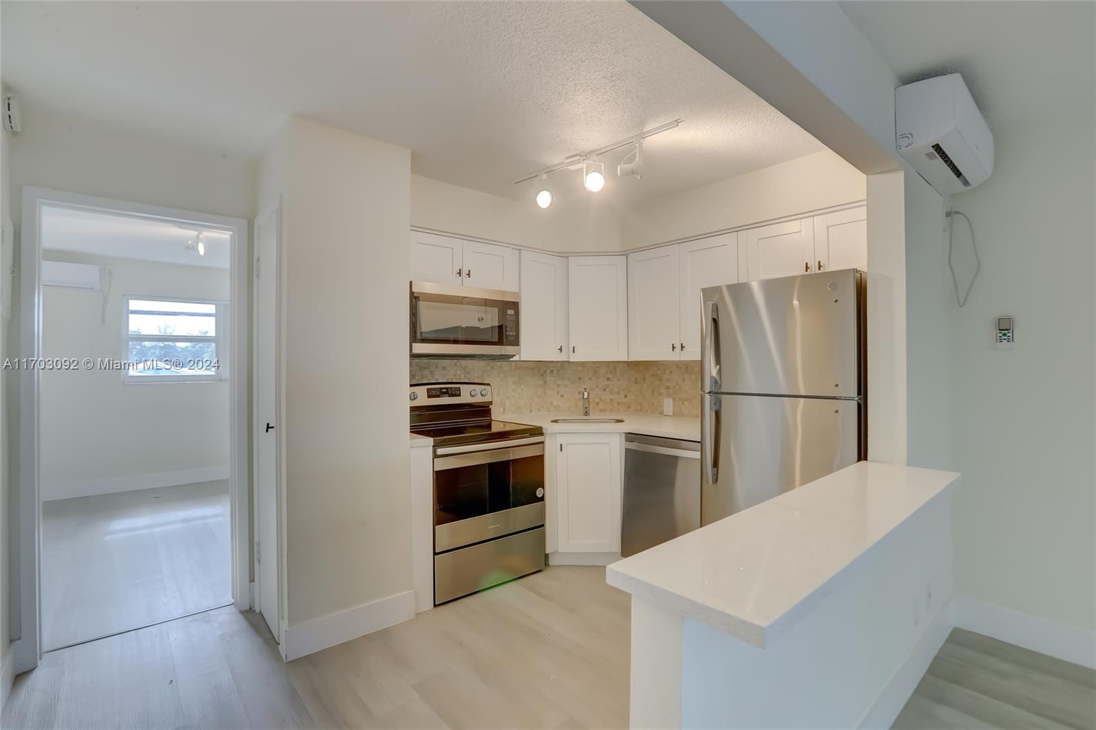 a kitchen with a refrigerator a stove top oven and cabinets