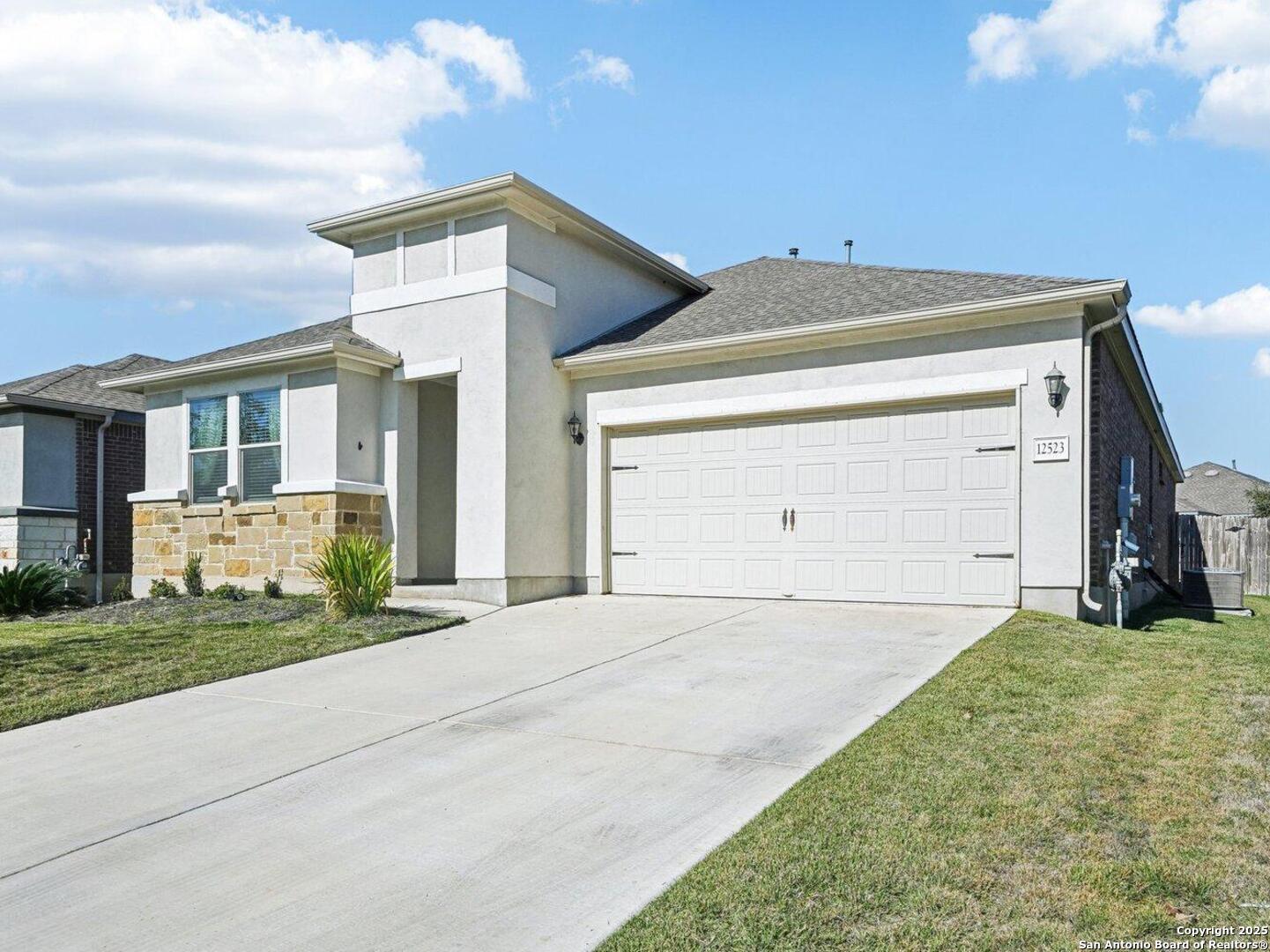 a front view of a house with a yard and garage