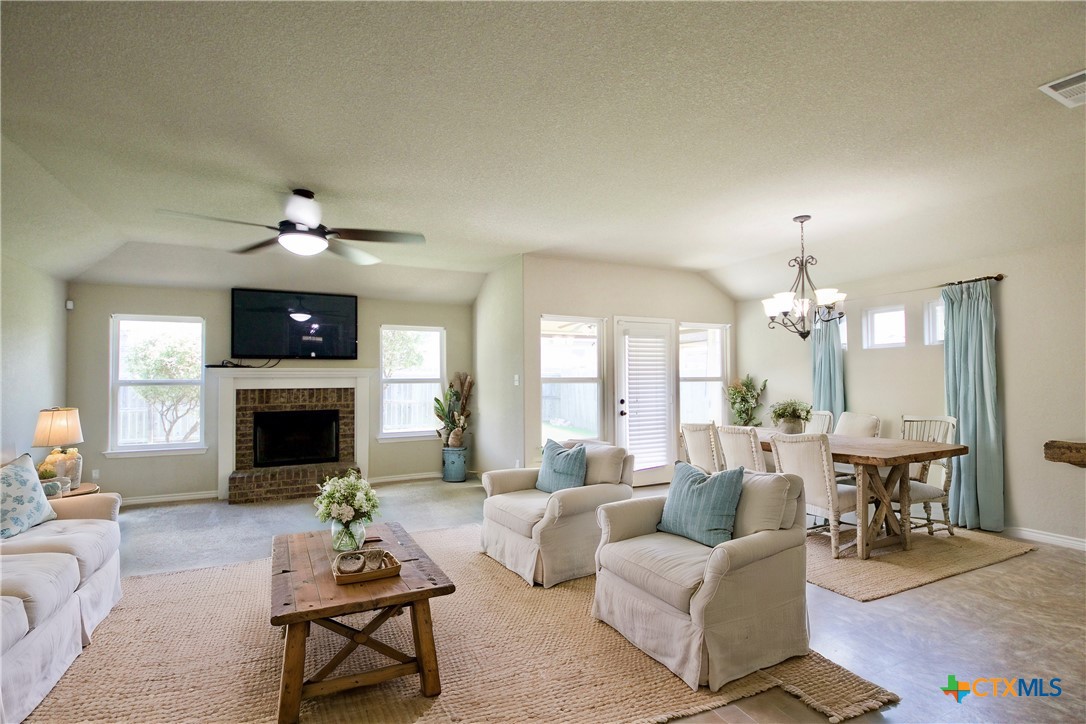 a living room with furniture a fireplace and a chandelier