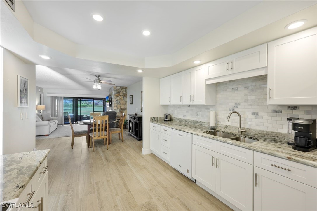 a kitchen with white cabinets sink and dining table