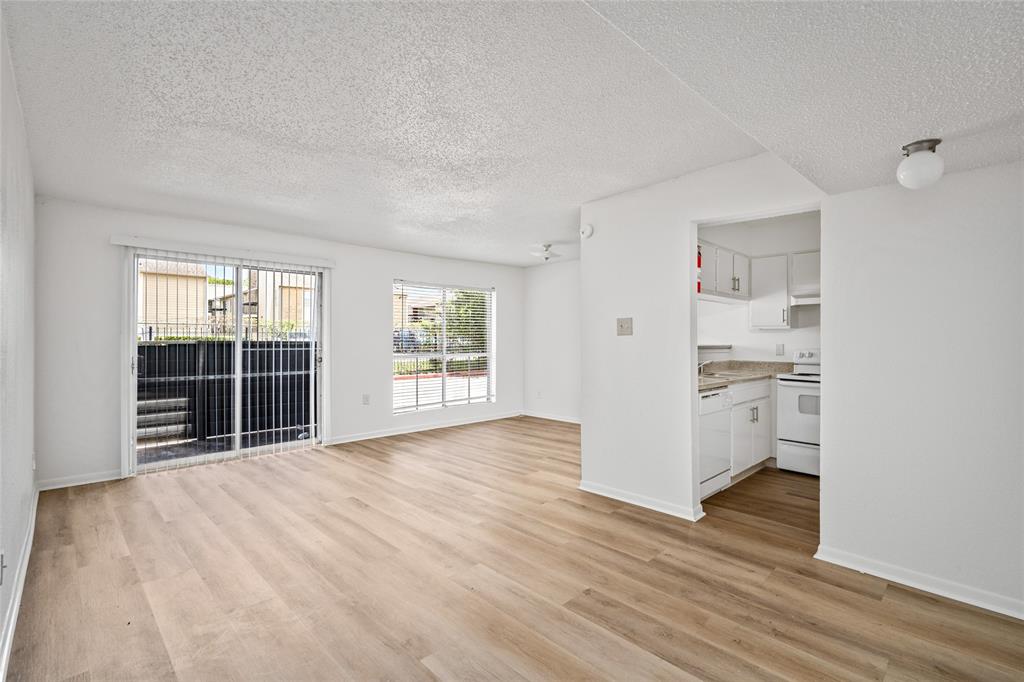 a view of empty room with wooden floor and windows