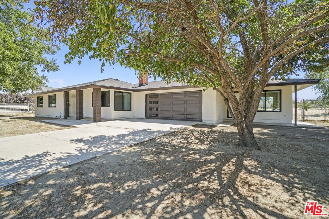 a front view of a house with a tree