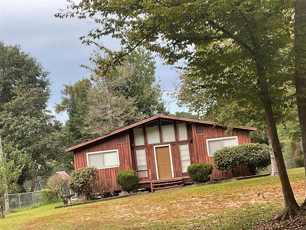 a front view of house with yard and trees around