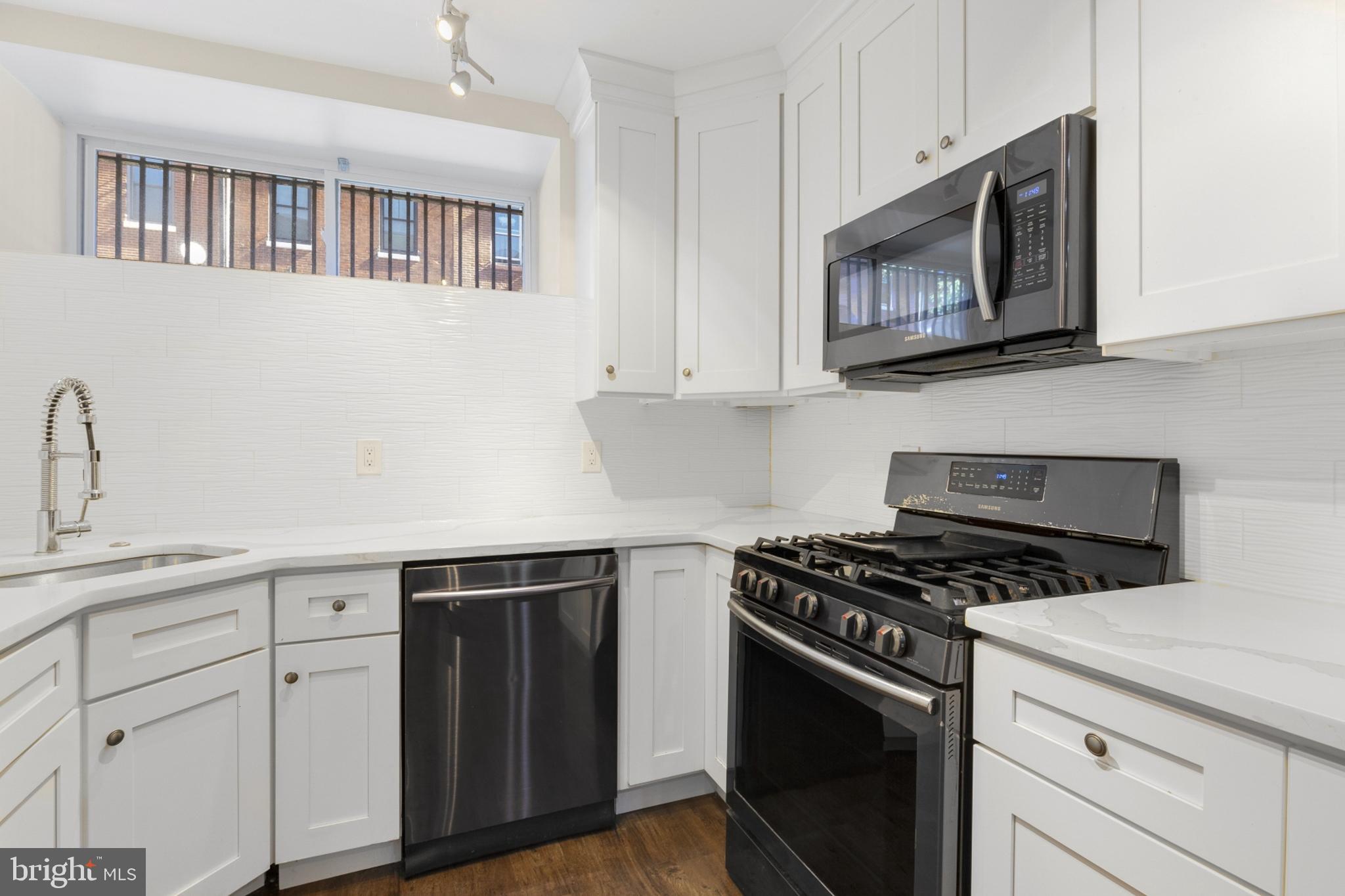 a kitchen with cabinets stainless steel appliances and a sink