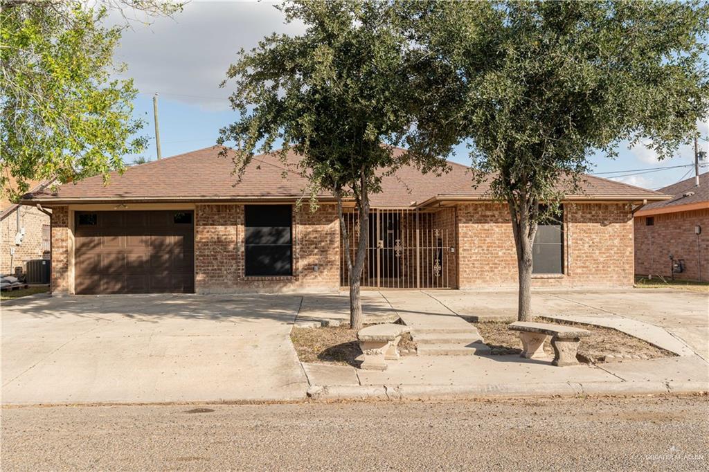 a front view of a house with a tree