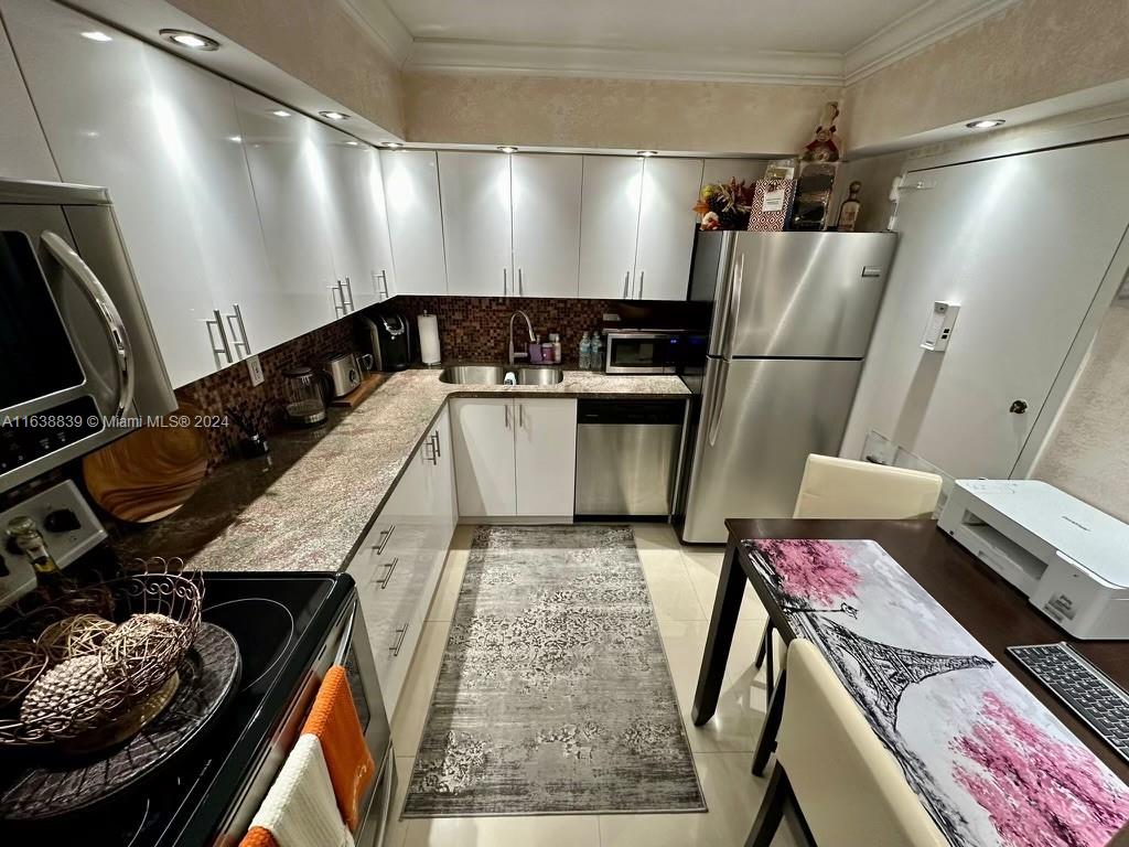 a kitchen with stainless steel appliances granite countertop a refrigerator and a stove