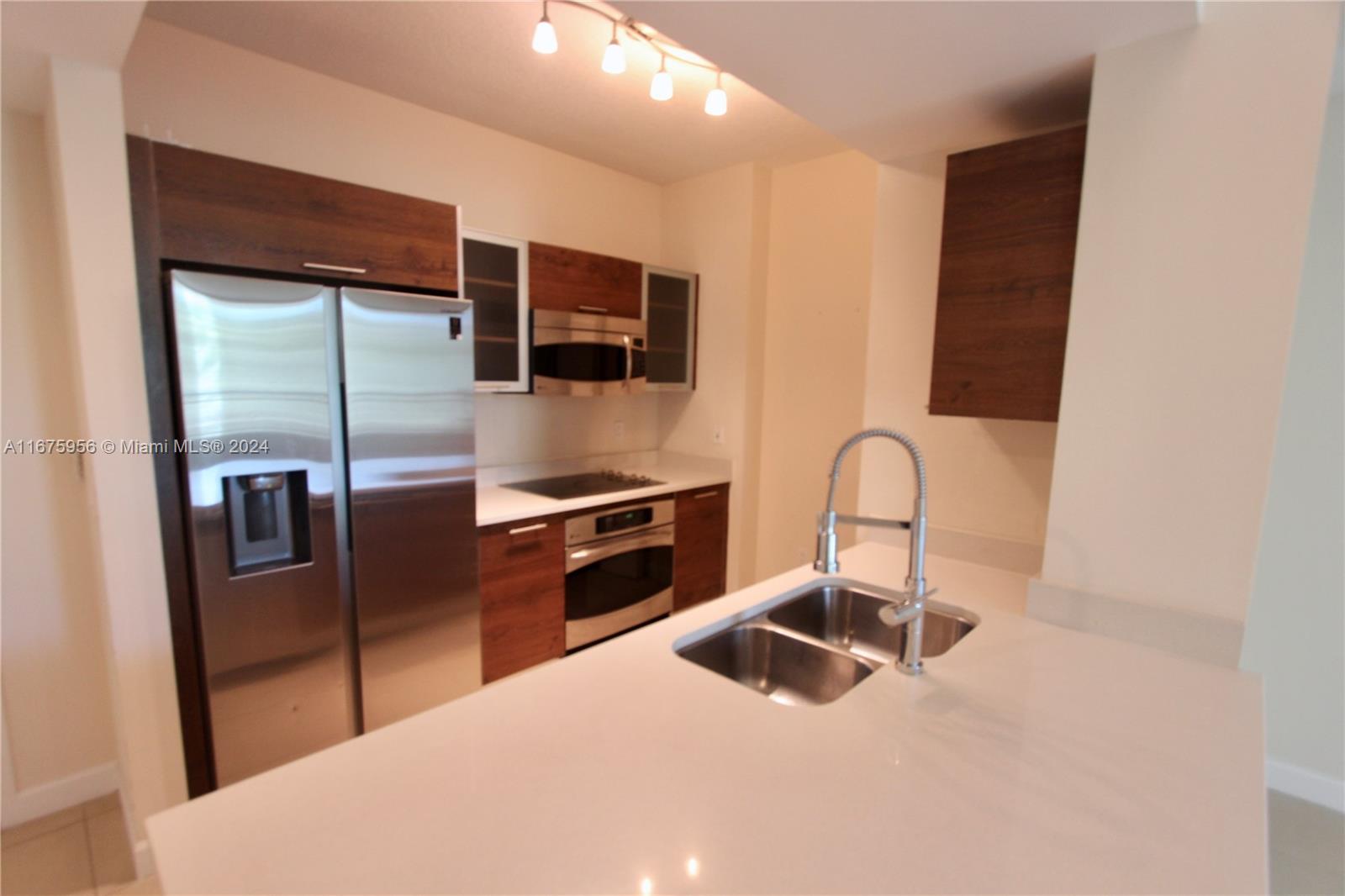 a kitchen with stainless steel appliances kitchen island a refrigerator sink and stove