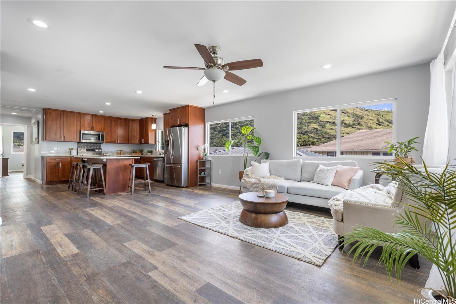 a living room with furniture kitchen view and a large window