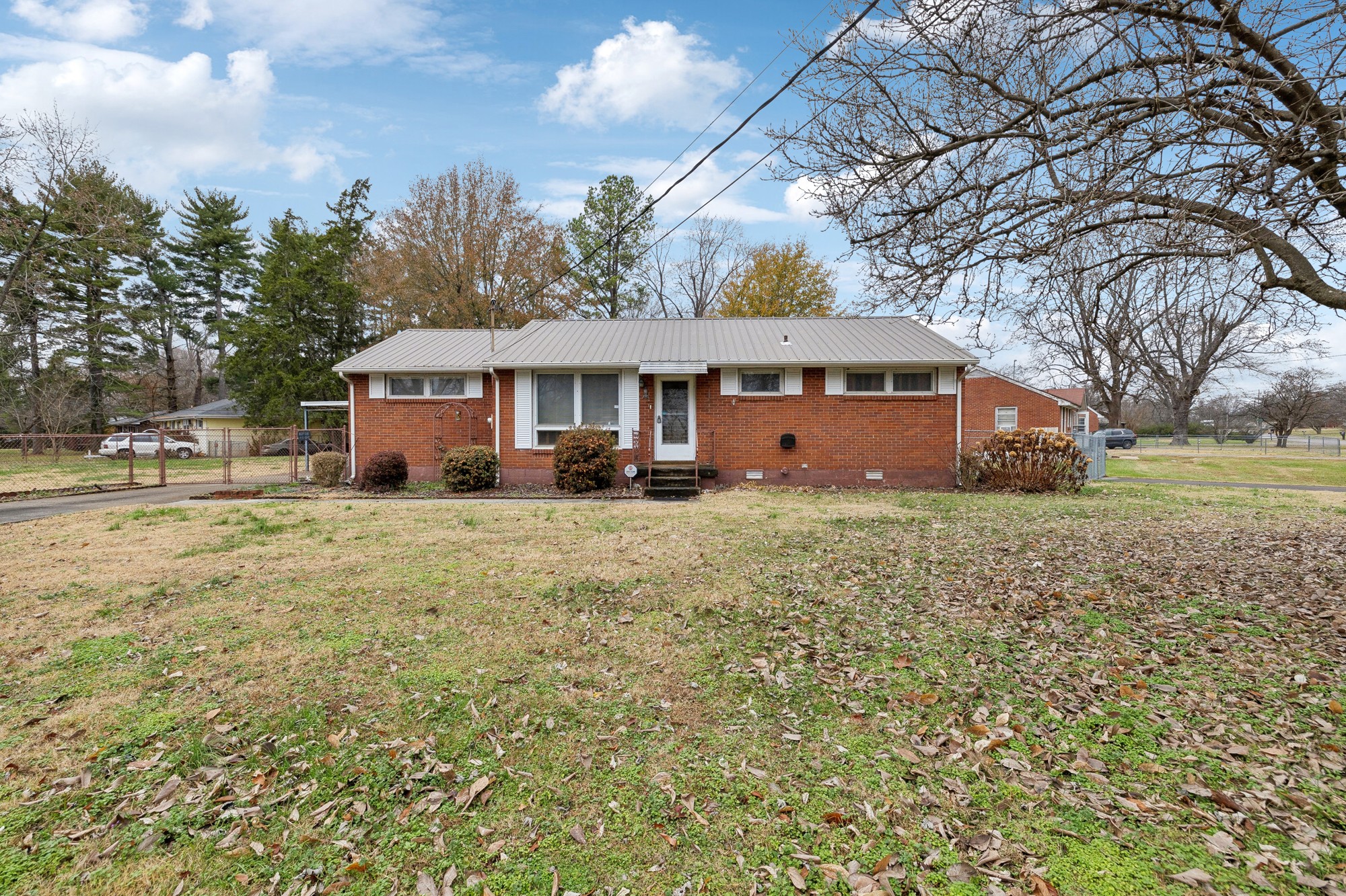 a front view of house with yard and trees in the background