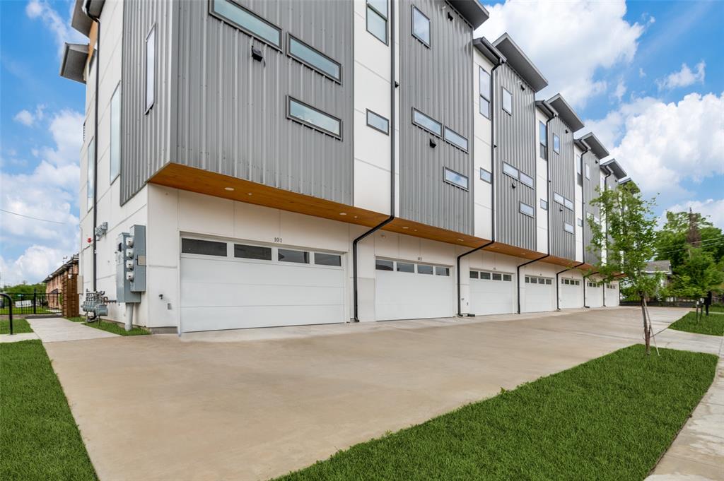 a view of a white building with a yard