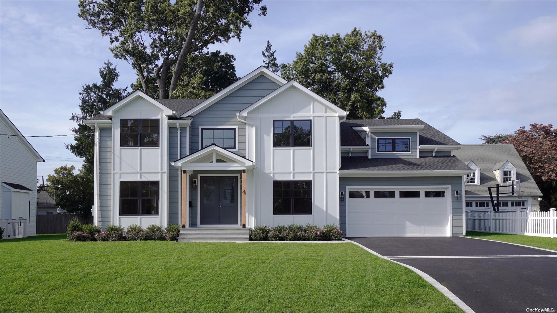 a front view of a house with a yard and trees