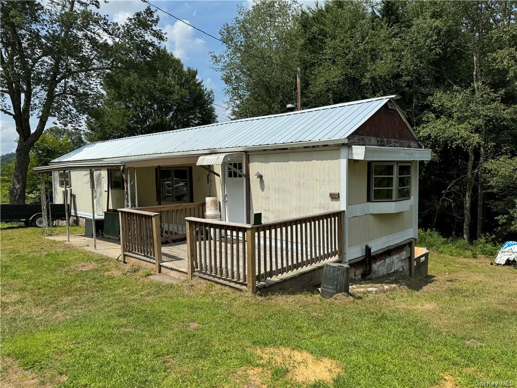 a view of a house with a yard and deck