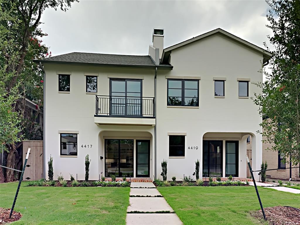 a front view of a house with a yard and trees