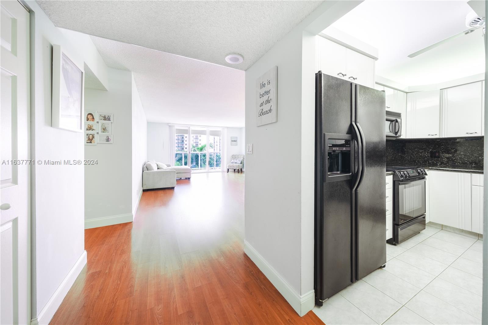 a kitchen with stainless steel appliances a refrigerator and wooden floor