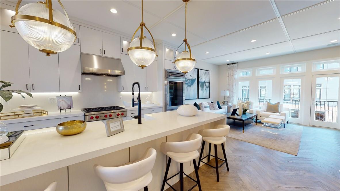 a kitchen with sink a stove and chairs with wooden floor