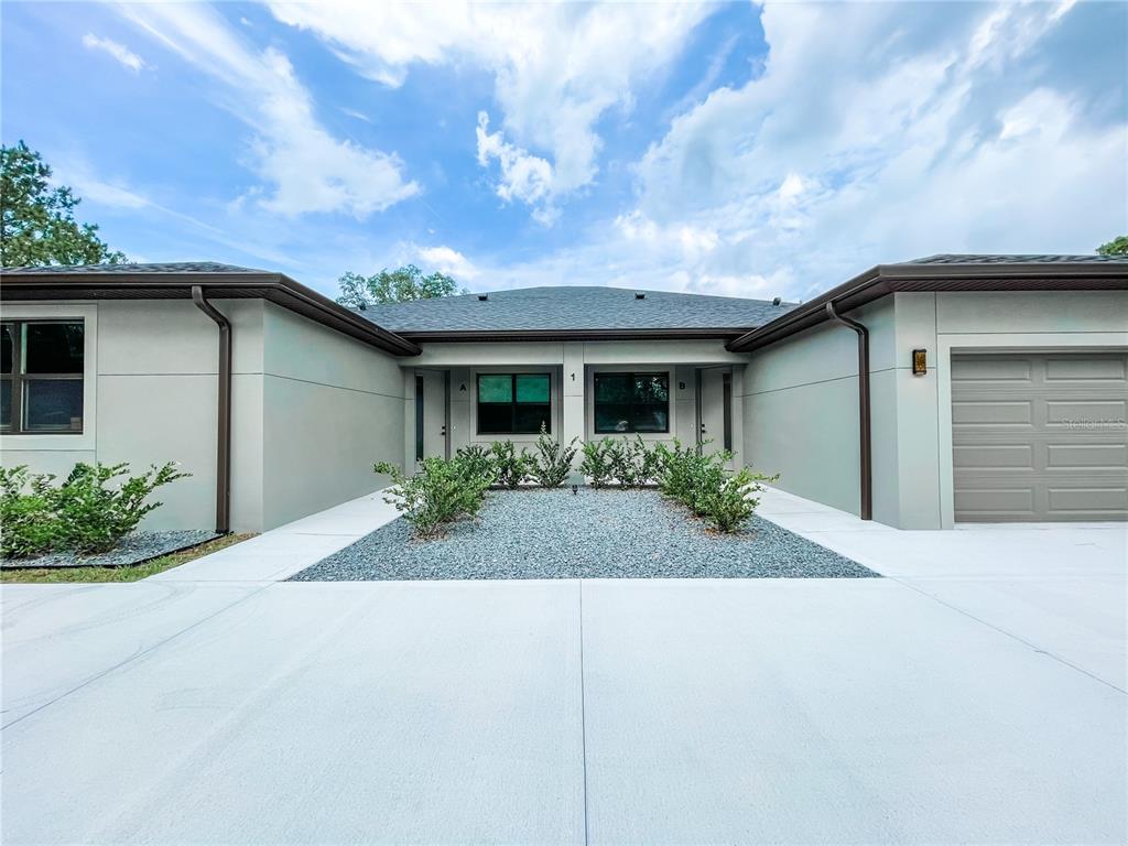 a front view of house with yard and trees around