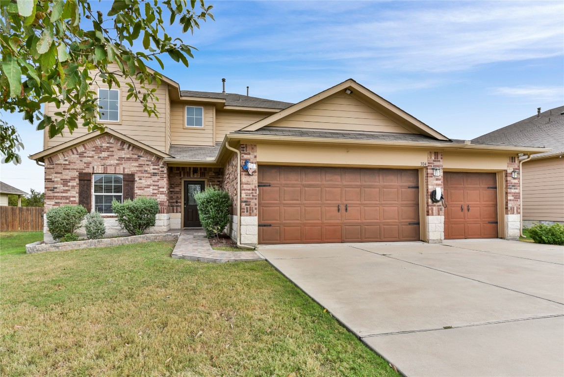 a front view of a house with a yard and garage