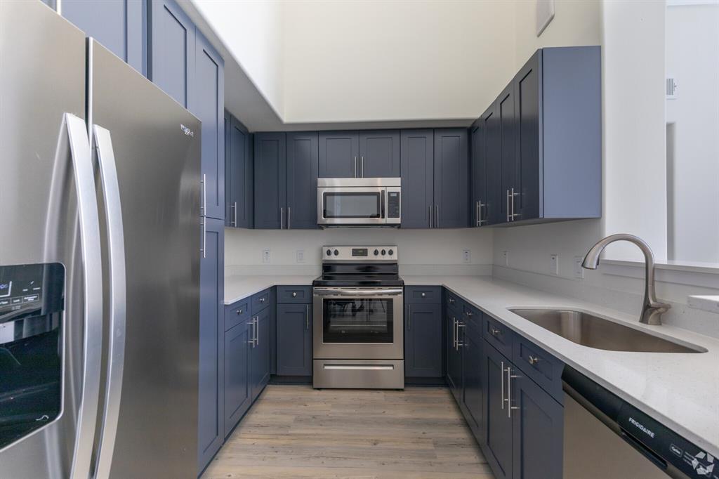 a kitchen with stainless steel appliances granite countertop a refrigerator stove and sink