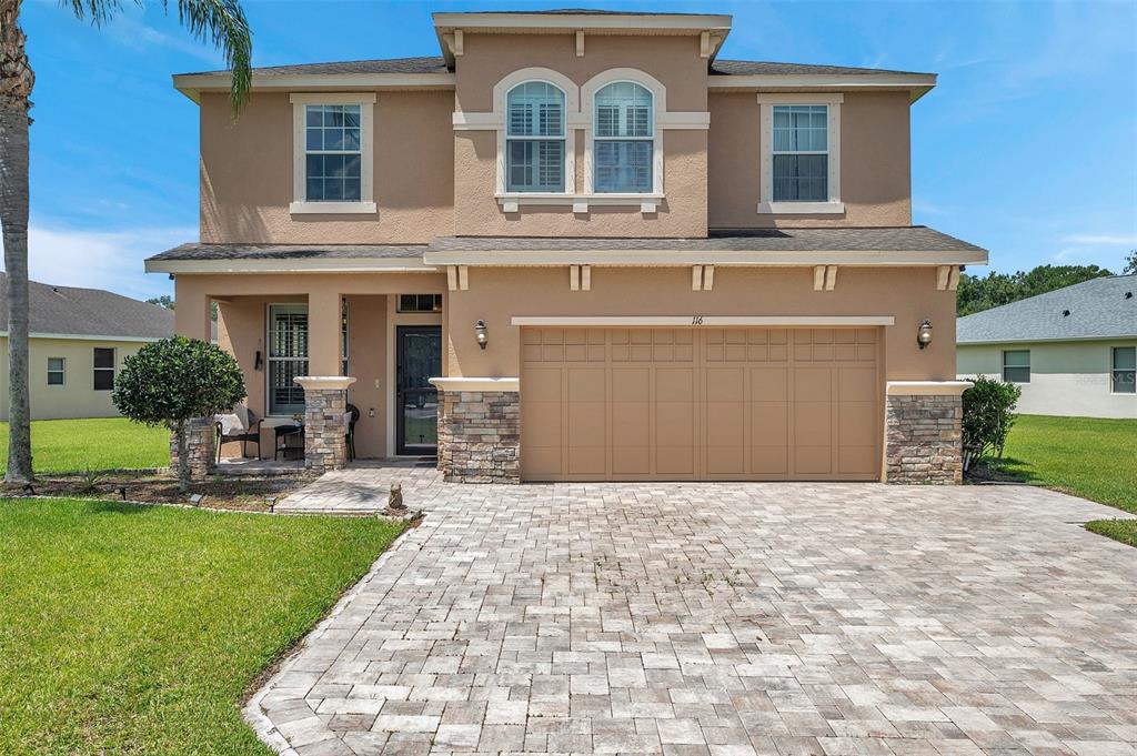 a front view of a house with a yard and garage