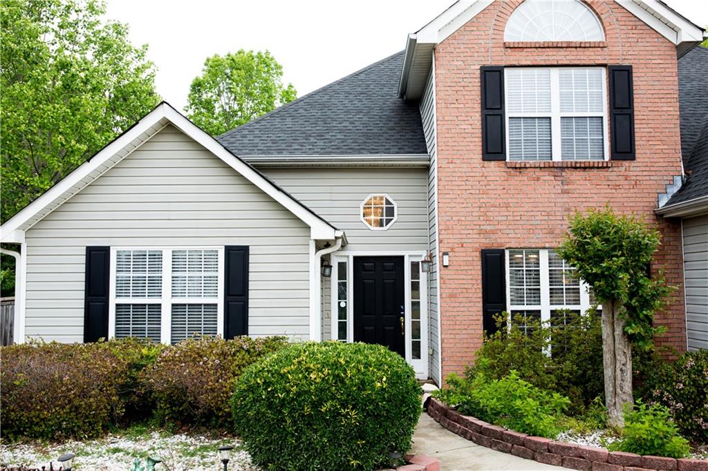 a view of a house with a yard and potted plants