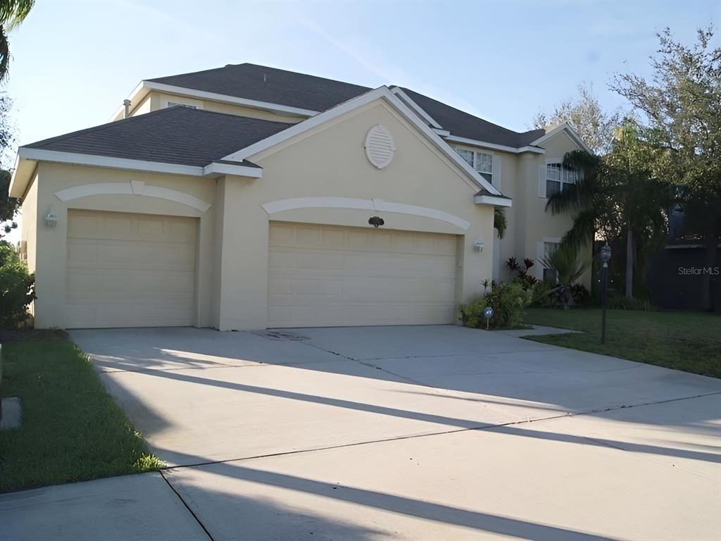 a front view of a house with garage and plants