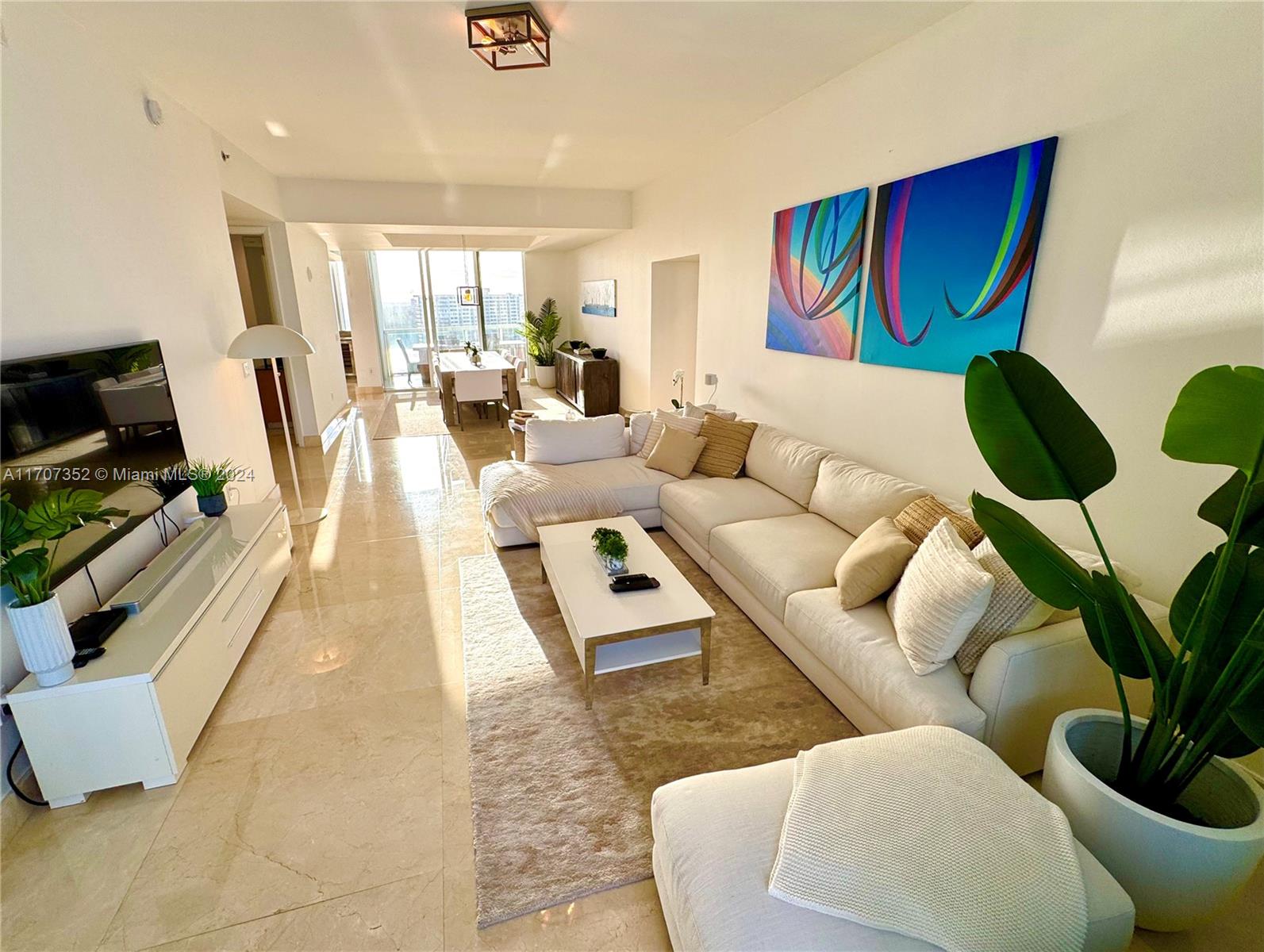 a living room with furniture and a potted plant